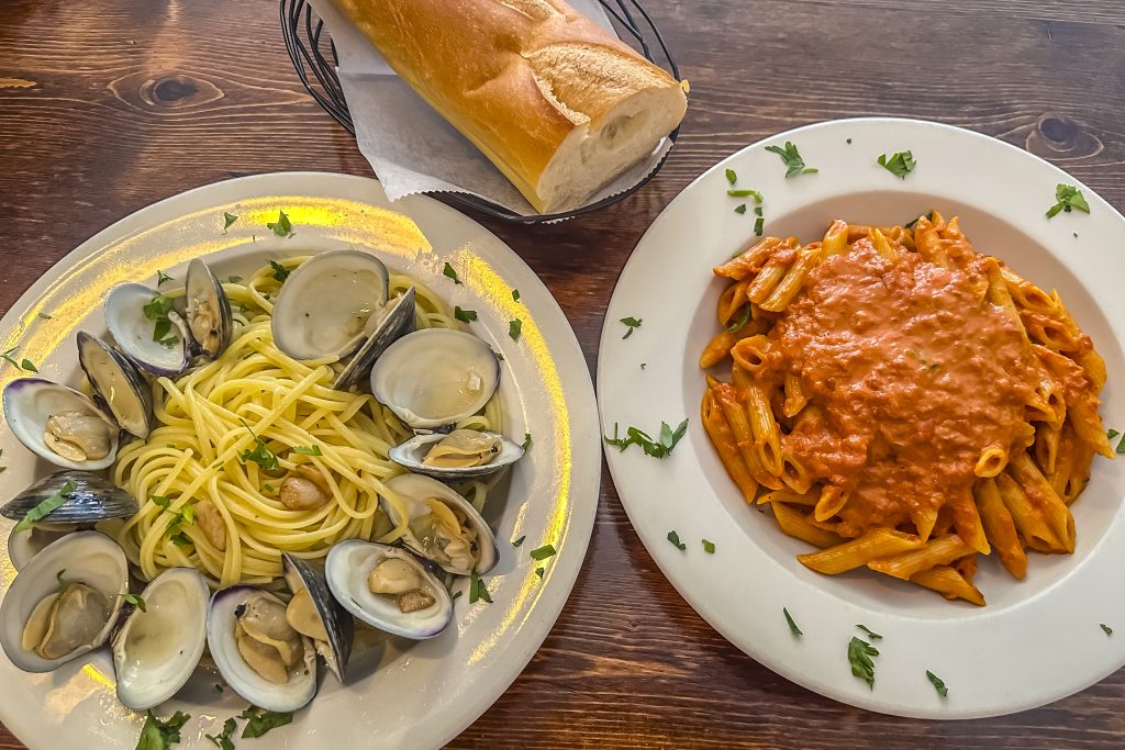 Plate of Linguini with while clam sauce and a plate of ziti marinara sauce.