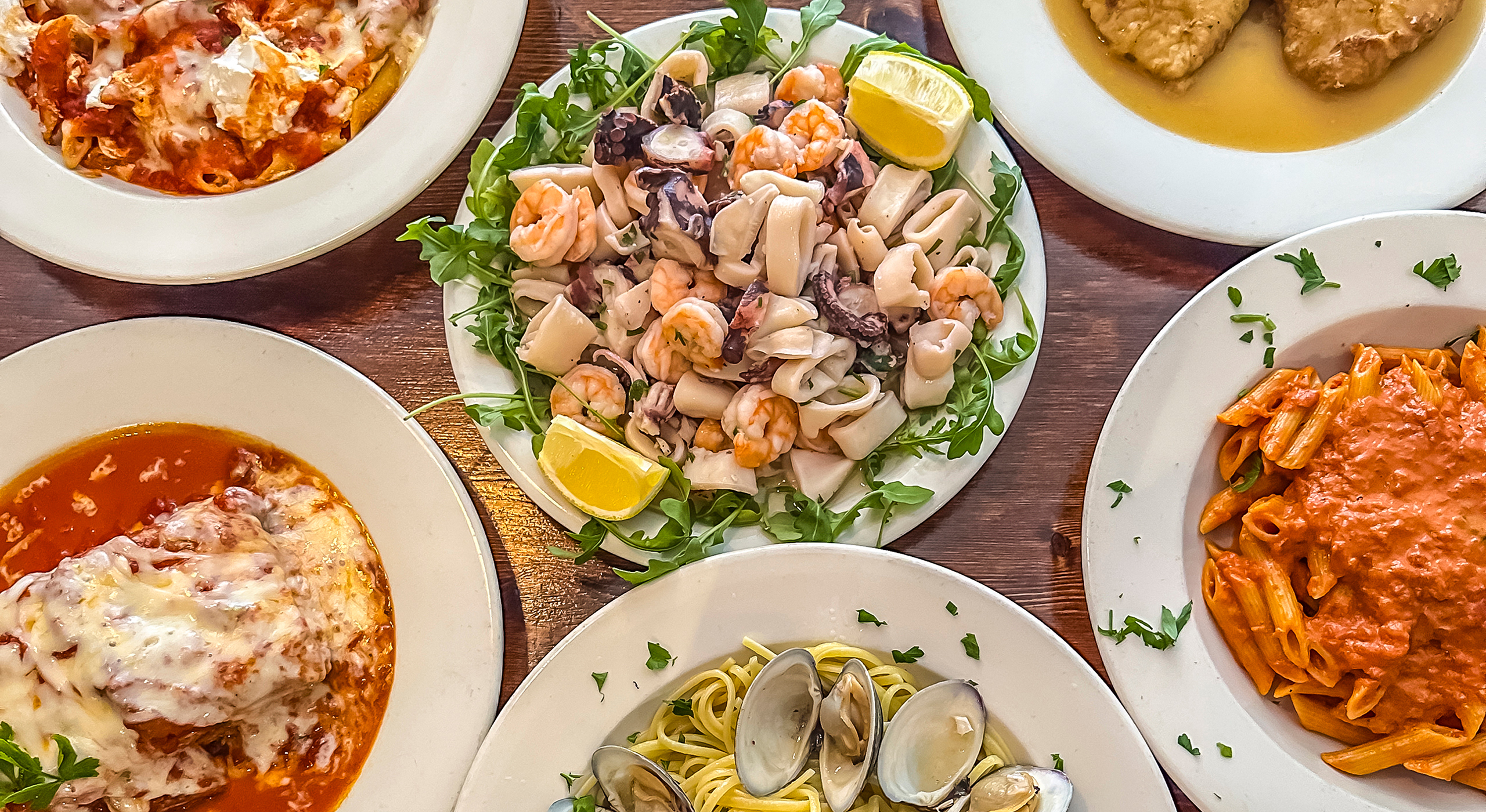 6 dishes from Vinny's of carroll Gardens, Going counter clockwise is Rigatoni Norma, lasagna, Linguini with clam sauce, Penne Marinara and Chicken Francese. In the middle is Seafood salad.